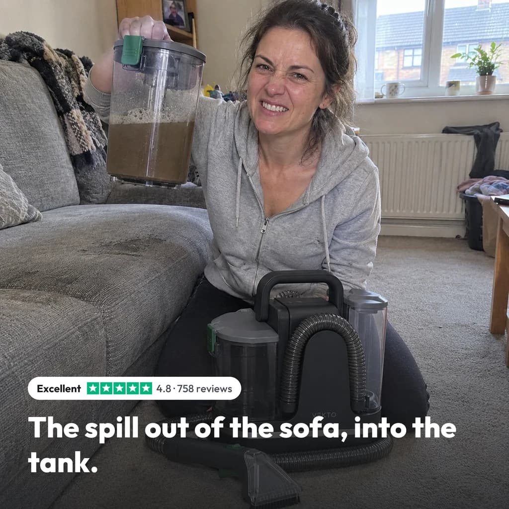 The spill out of the sofa, into the tank: a woman holding up the dirty tank of the Vekto Spot Cleaner P30 by her sofa, rated 4.8 from 758 reviews