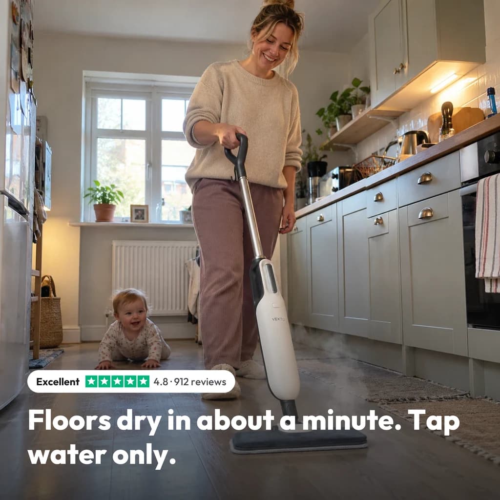 Floors dry in about a minute with tap water only: a mum steaming the kitchen floor with the Vekto Steam Mop S20 while her baby crawls behind her, rated 4.8 from 912 reviews