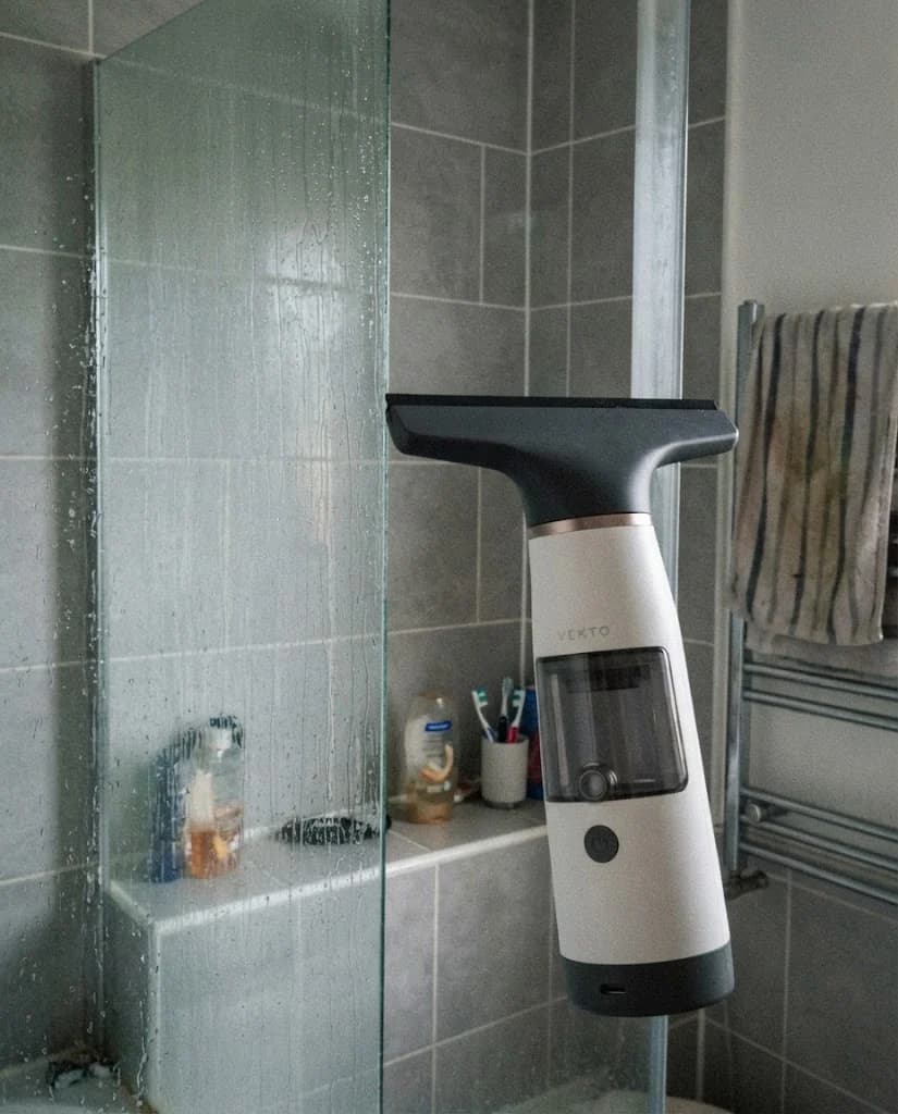 The Vekto Window Vac W10 blade halfway down a fogged pane, a clear dry stripe behind it