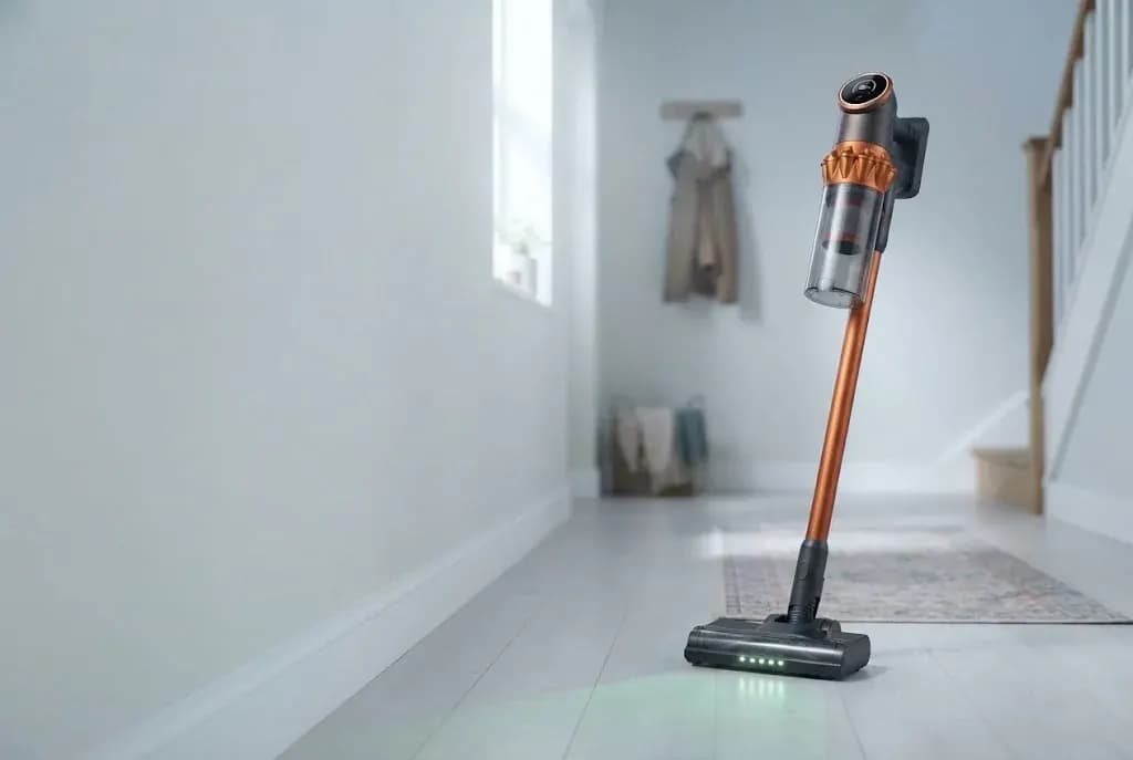 The Vekto Vacuum V18 standing on its own in a bright hallway, its green light on the floor