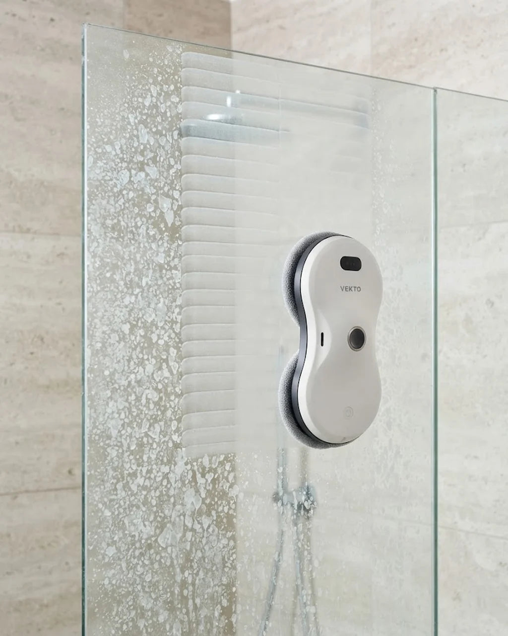Le robot lave-vitre Vekto sur une paroi de douche en verre