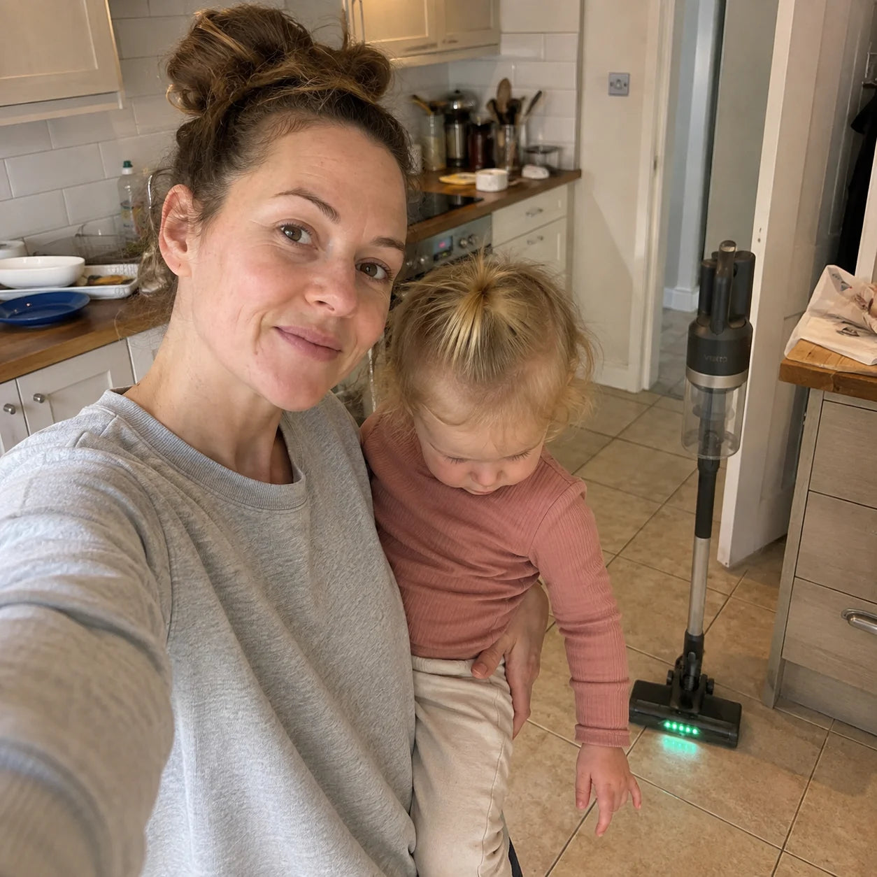 Hannah with her toddler in the kitchen, the Vekto Stick standing behind them